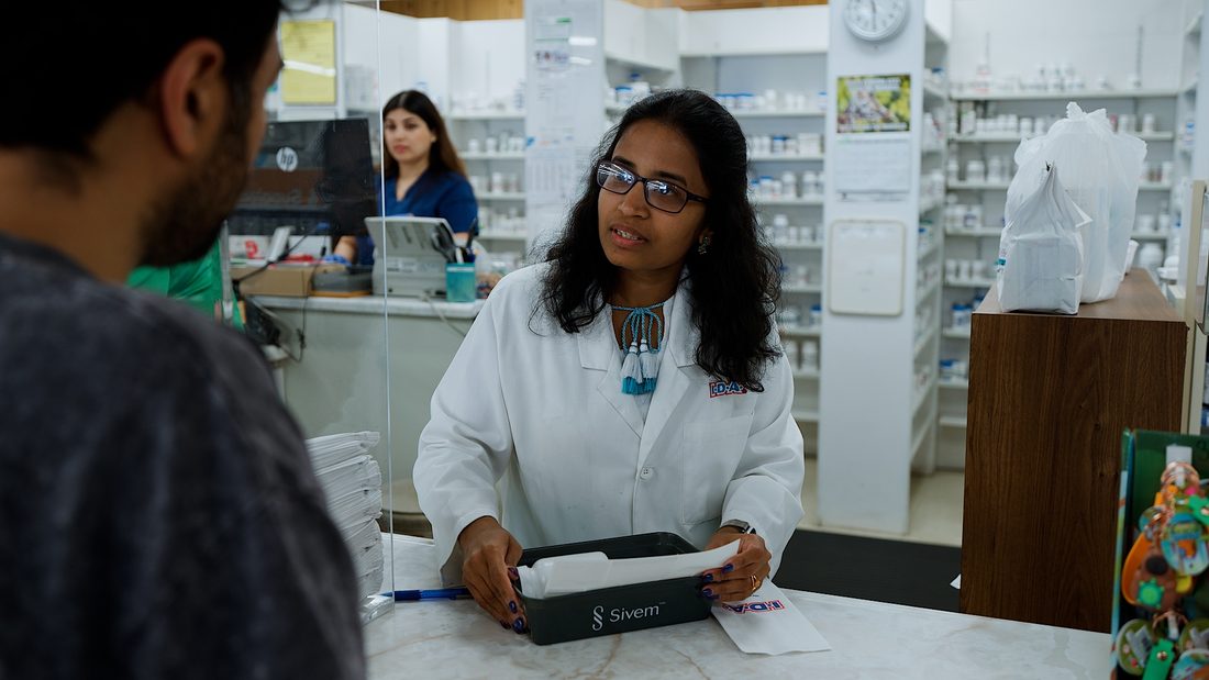 Pharmacist consulting with a customer at the counter