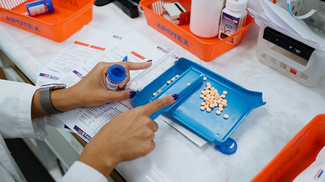 Pharmacist counting pills at the dispensing tray