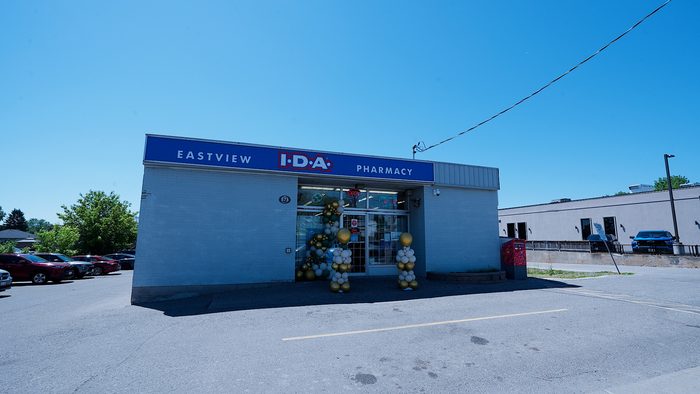 Wide view of the Eastview I.D.A. Pharmacy storefront and parking lot